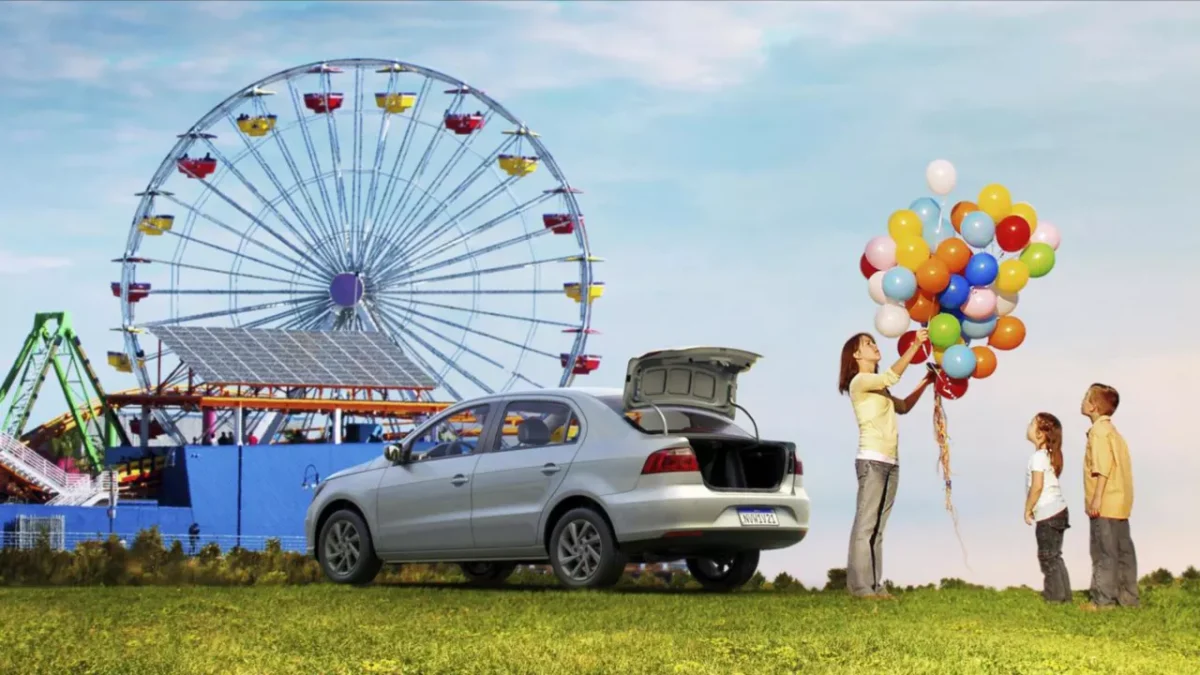 Família em parque de diversões, ao lado do carro VW Voyage