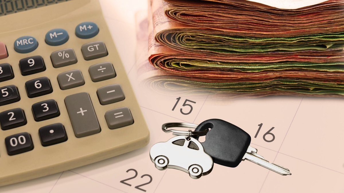 notas de dinheiro, ao lado de uma chave de carro e uma calculadora