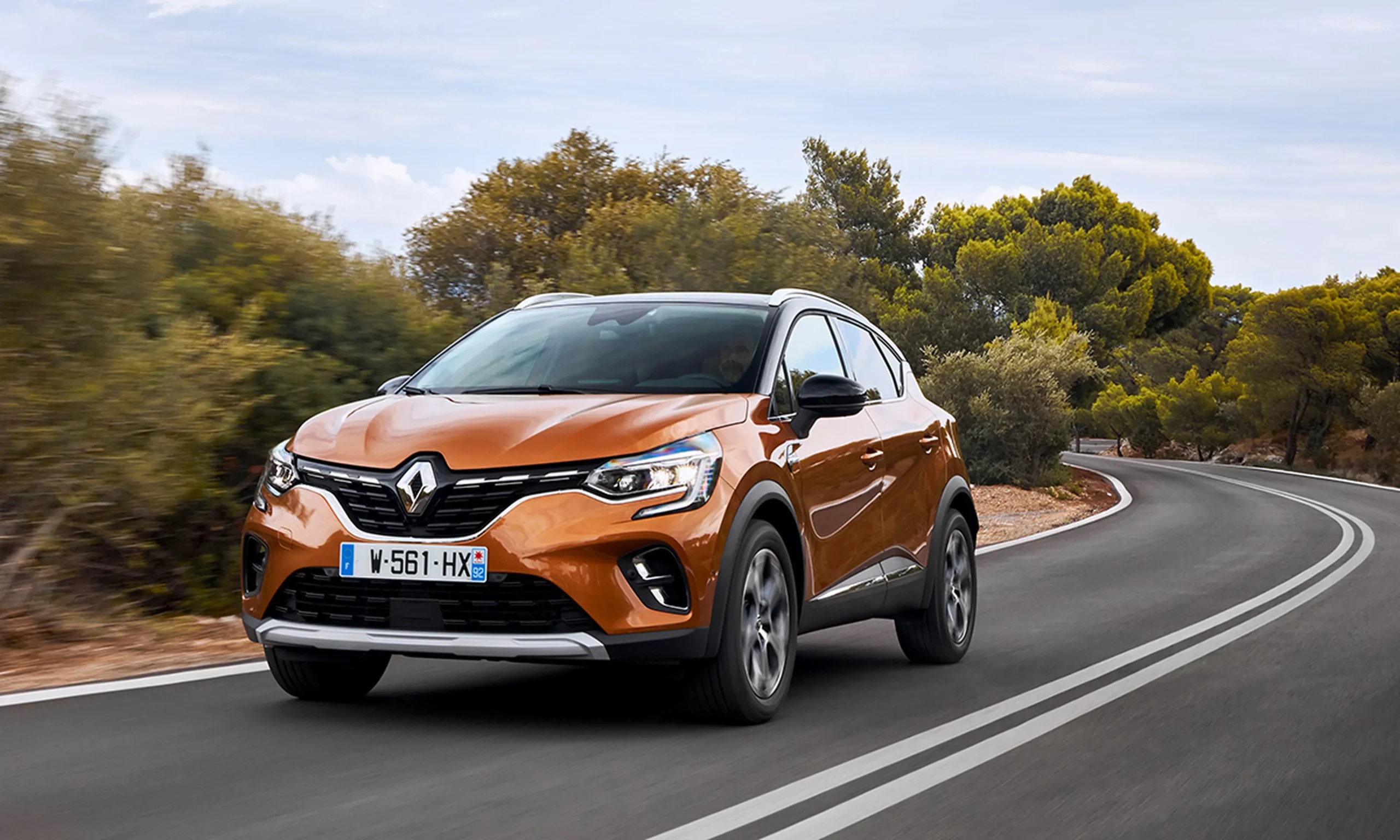 Dianteira do Renault Captur 2024 na cor laranja, em movimento na estrada