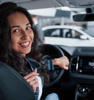 Mulher sorrindo dentro de um carro