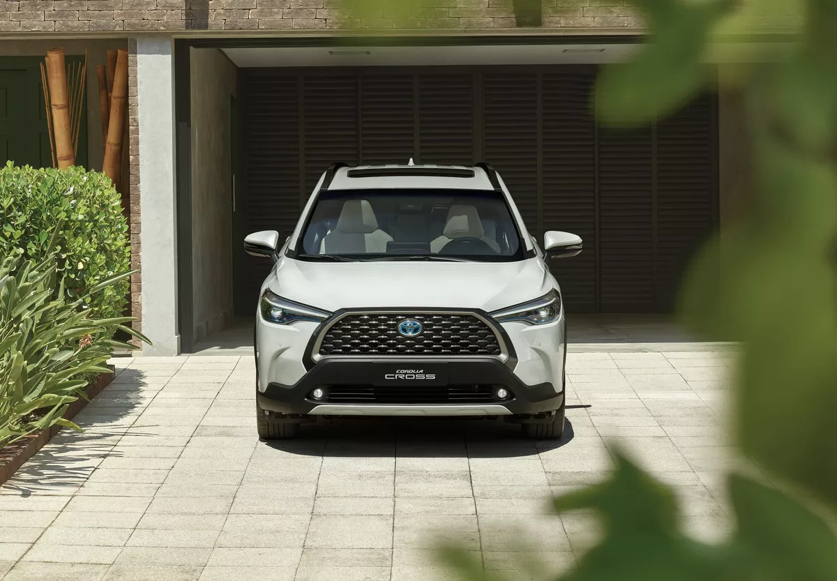 Dianteira do Toyota Corolla XRE Cross 2024 na cor branca, saindo de uma garagem